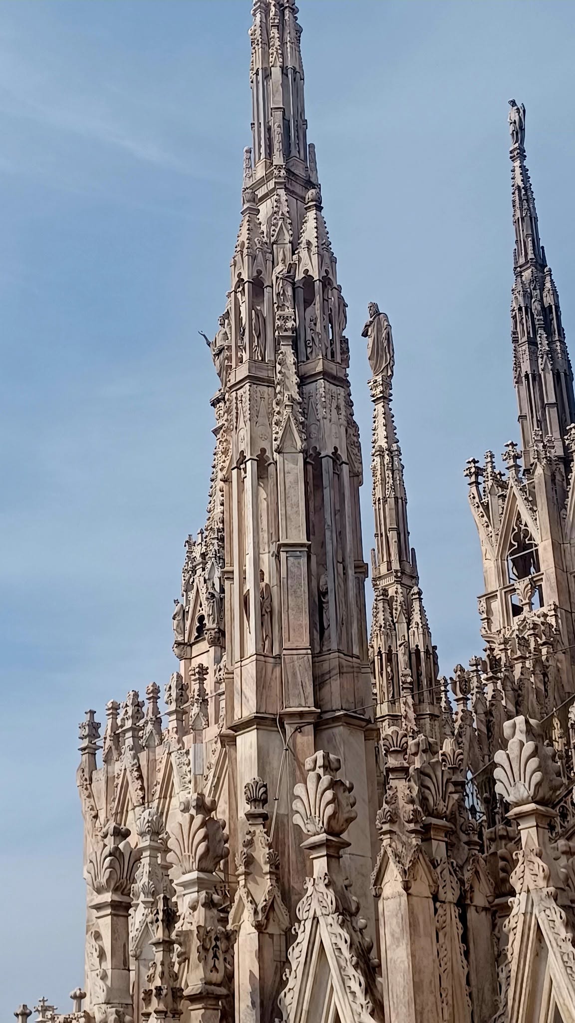 Visitors walking among spires on the roof of Milan Cathedral